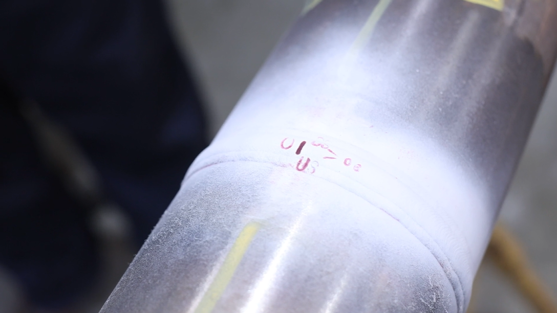 Defect testing on welds with white paint showing red identified defects